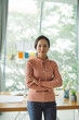 © Marc Tran/Stocksy - Smiling young businesswoman standing in front of her workplace