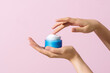 © Marc Tran/Stocksy - Skin care product. Female hand holding a face cream jar