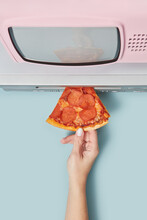 Pizza Being Pushed In VCR Player By Woman's Hand.