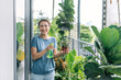 © Marc Tran/Stocksy - Housewife holding spray with water and humidifying her plants