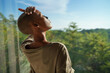 © Jovo Jovanovic/Stocksy - Bald woman enjoying sunlight through window at home