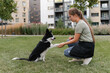 © Alina Hvostikova/Stocksy - Woman teaching dog to give paw