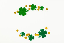 St Patrick's Day Concept. Creative Layout With Frame Of Four-leaf Clover And Gold Coins On White Background. Flat Lay, Top View.