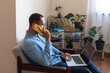 © Demetr White/Stocksy - man talking on the phone and working on a laptop