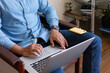 © Demetr White/Stocksy - photo of the hands of a man sitting in a chair at a laptop