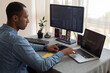 © Demetr White/Stocksy - man working at home with two monitors