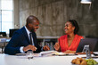 © BONNINSTUDIO/Stocksy - Happy coworkers discussing project in office