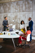 © BONNINSTUDIO/Stocksy - Group of coworkers discussing project in office