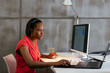 © BONNINSTUDIO/Stocksy - Focused woman working on computer in office