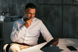 © BONNINSTUDIO/Stocksy - Thoughtful man using tablet in office
