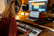 © Jimena Roquero/Stocksy - Back of Music producer at home studio using keyboard controller