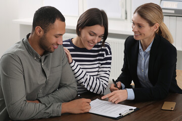 Canvas Print - Professional notary helping couple with paperwork in office