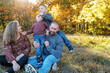 © Serena Burroughs/Stocksy - Young family with two boys playing outside in autumn
