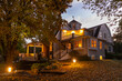© Raymond Forbes LLC/Stocksy - Front of Craftsman house with porch in Autumn at sunset with foliage