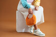 © BONNINSTUDIO/Stocksy - Crop stylish woman sitting on box