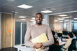 © Pedro Merino/Stocksy - Portrait of smiling young black man in coworking