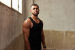 © Javier Díez/Stocksy - Confident athletic guy standing  in shabby gym