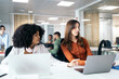 © Pedro Merino/Stocksy - Office colleagues working in a coworking space with laptops