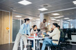 © Pedro Merino/Stocksy - Office colleagues working in a coworking space with laptops