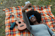© Raymond Forbes LLC/Stocksy - Beautiful Black Girl selfie Listening to music outdoors on blanket