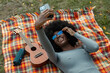 © Raymond Forbes LLC/Stocksy - Beautiful Black Girl Listening to music outdoors taking selfie