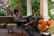 © Raymond Forbes LLC/Stocksy - African American hygge  Sitting at home porch with tablet computer