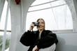 © Nikita Sursin/Stocksy - Woman with camera ride Ferris wheel