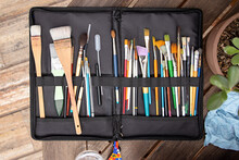 Artist brush case on wooden table seen from above