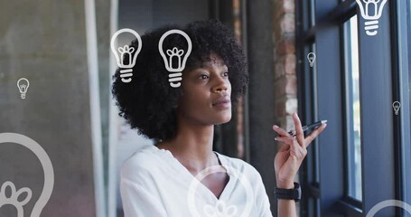 Sticker - Animation of portrait of lightbulb icons over african american businesswoman thinking