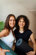 © Valentina Barreto/Stocksy - Girlfriends smiling holding yoga mat portrait