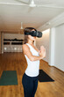 © Valentina Barreto/Stocksy - Woman practicing yoga with VR glasses