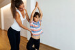 © Valentina Barreto/Stocksy - Yoga trainer corrects child's posture