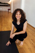 © Valentina Barreto/Stocksy - Happy woman in yoga studio portrait