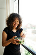 © Valentina Barreto/Stocksy - Cheerful woman eating salad after yoga class