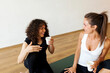 © Valentina Barreto/Stocksy - Young girlfriends tlking during yoga class