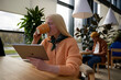 © Elenka Kharichka/Stocksy - Woman drinking hot beverage using tablet