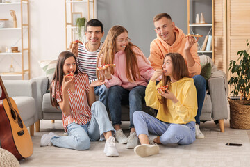 Wall Mural - Group of friends eating tasty pizza in living room