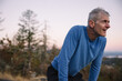 © Rob and Julia Campbell/Stocksy - Tired runner man on top of hill after summiting.