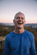 © Rob and Julia Campbell/Stocksy - Portrait of happy athletic runner outside during workout.