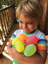 Kid Holding Water Balloons
