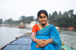 © Dream Lover/Stocksy - Young lady wearing traditional Sari sit on a boat over River Ganga
