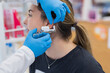 © Javier Pardina/Stocksy - Woman having ear piercing process