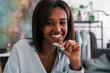 © Studio Marmellata/Stocksy - Joyful black lady eating sour candy belt and smiling