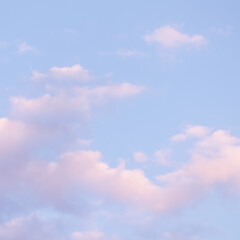 Wall Mural - blue sky background with white and pink clouds at sunset