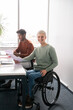 © Hernandez & Sorokina/Stocksy - Woman In The Wheelchair Portrait At Office Desk