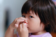 © Pansfun Images/Stocksy - Child uses tissue to stop nosebleed