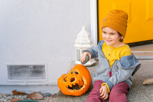 Happy Boy With Spooky Pumpkin Outside Home