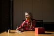 © Alba Vitta/Stocksy - Christmas mature woman at home writing a letter