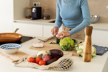 Mature Woman Cooking Vegetables In Kitchen