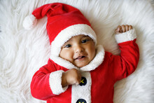 Cute Baby Wearing Santa Claus Costume Smiling At Camera
